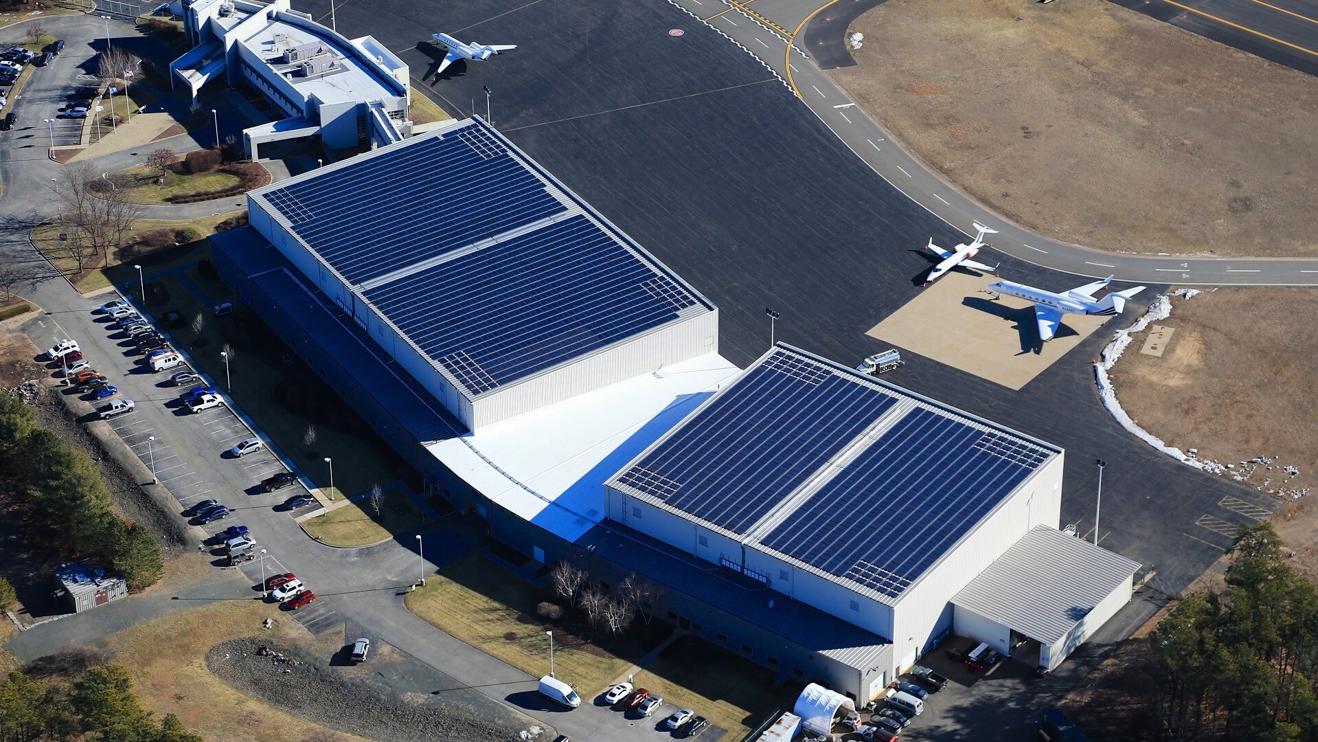 aerial view over airport buildings with solar panels on rooves