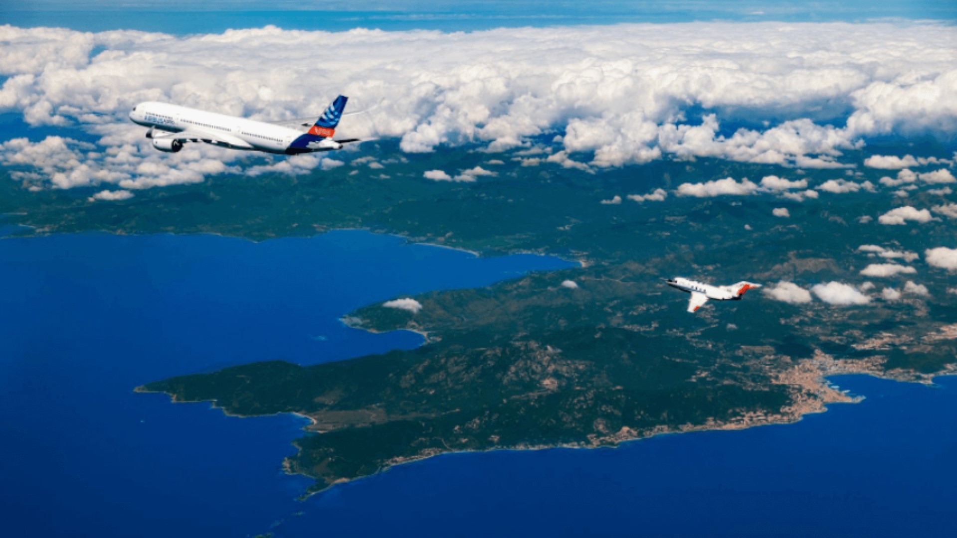 two airplanes flying in blue sky through white clouds
