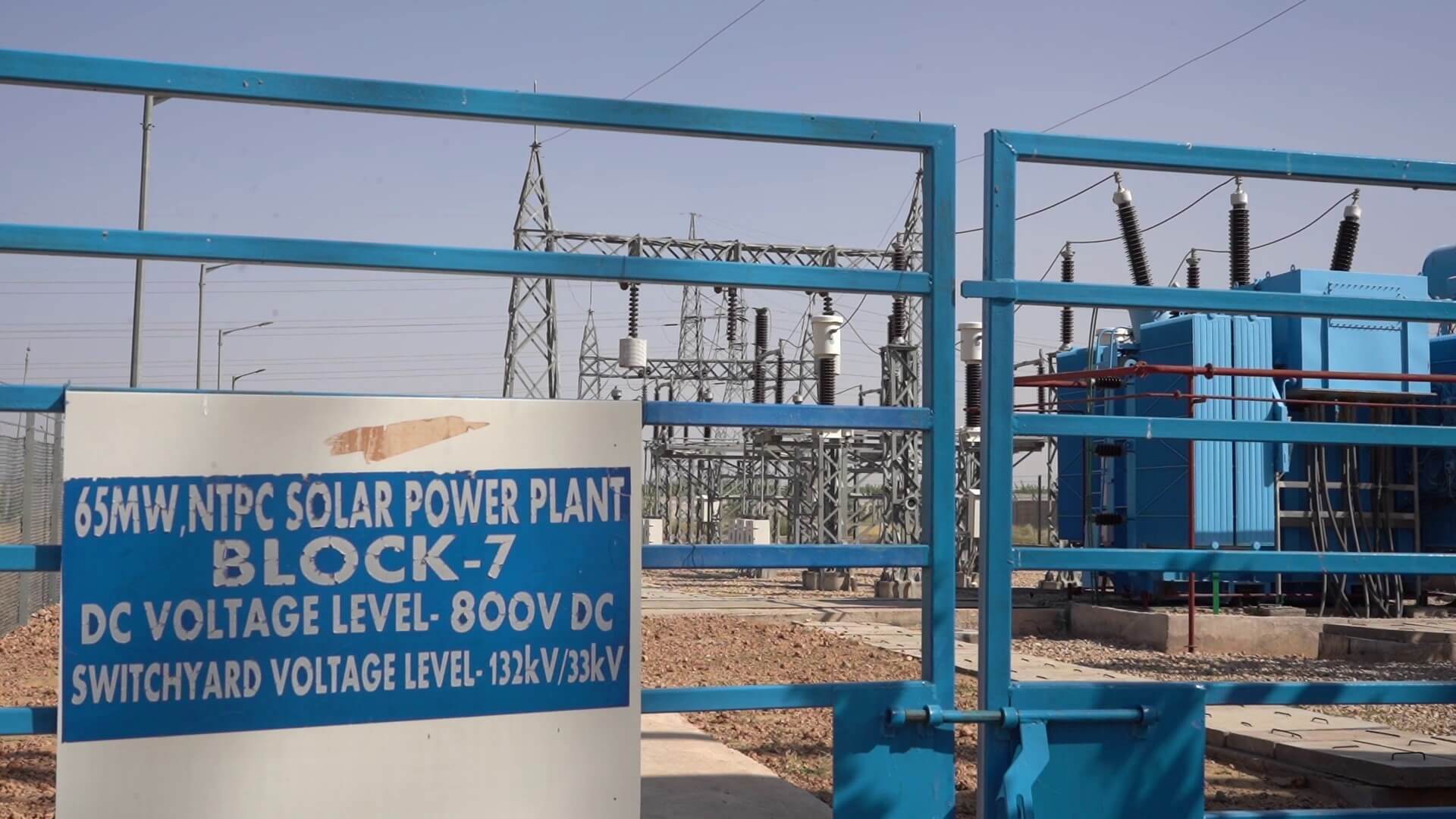electricity generating equipment and power lines set behind blue barrier