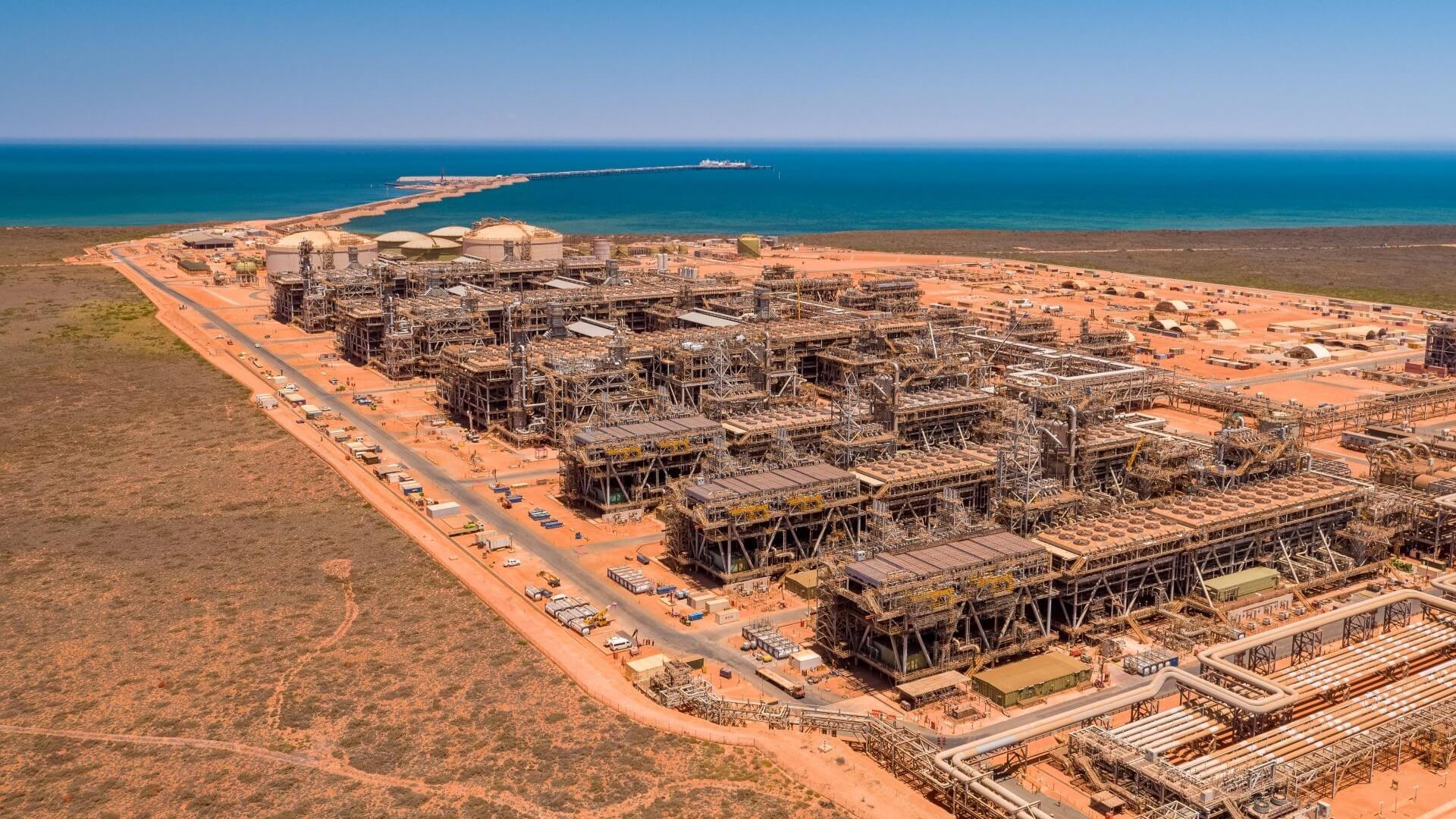 aerial view over plant and pipework with sea behind