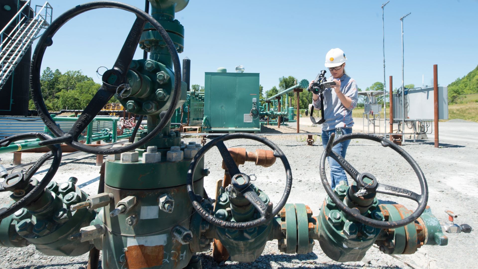 Engineer using handheld equipment to monitor methane emissions