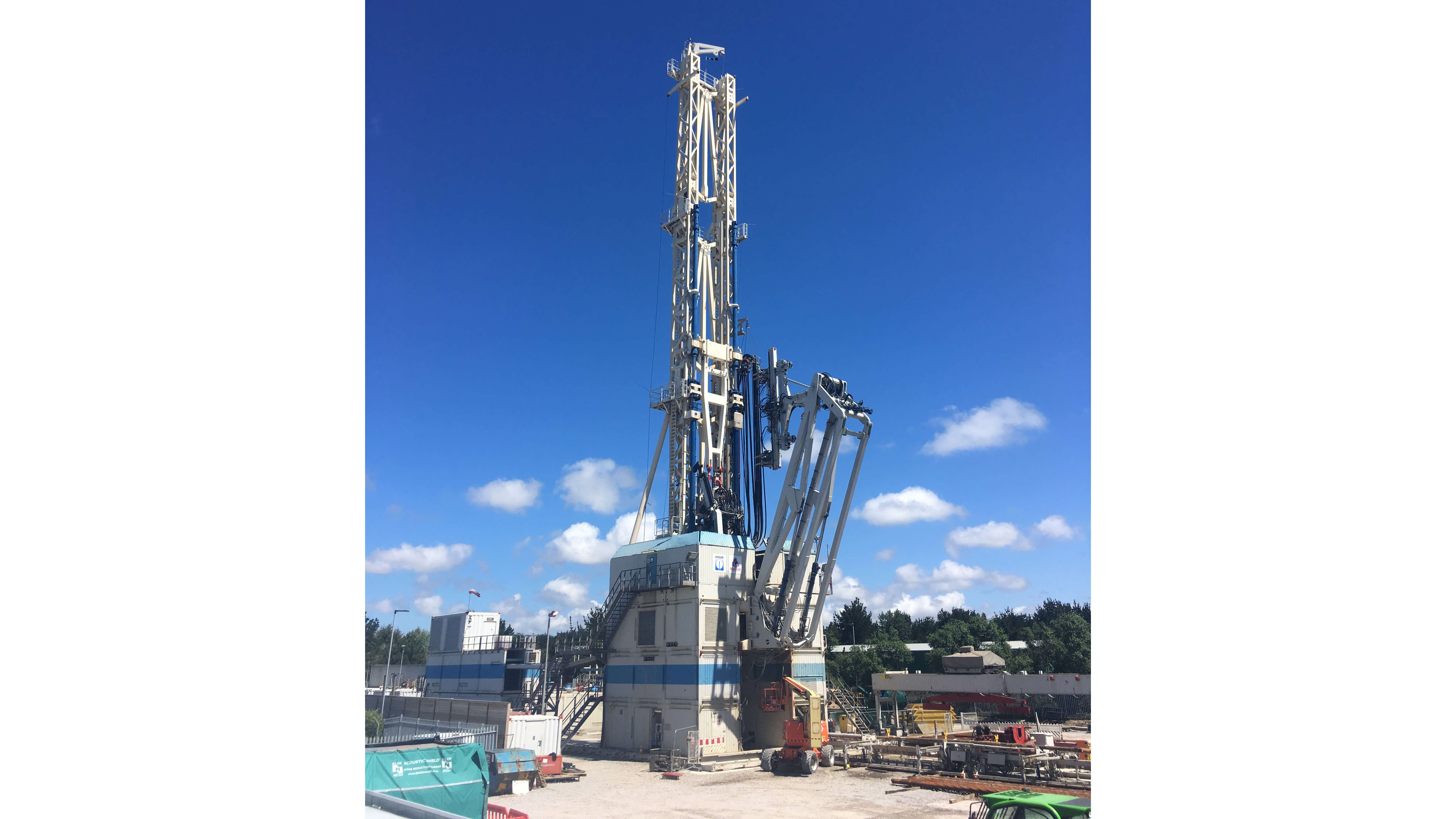 small drilling rig set against blue sky