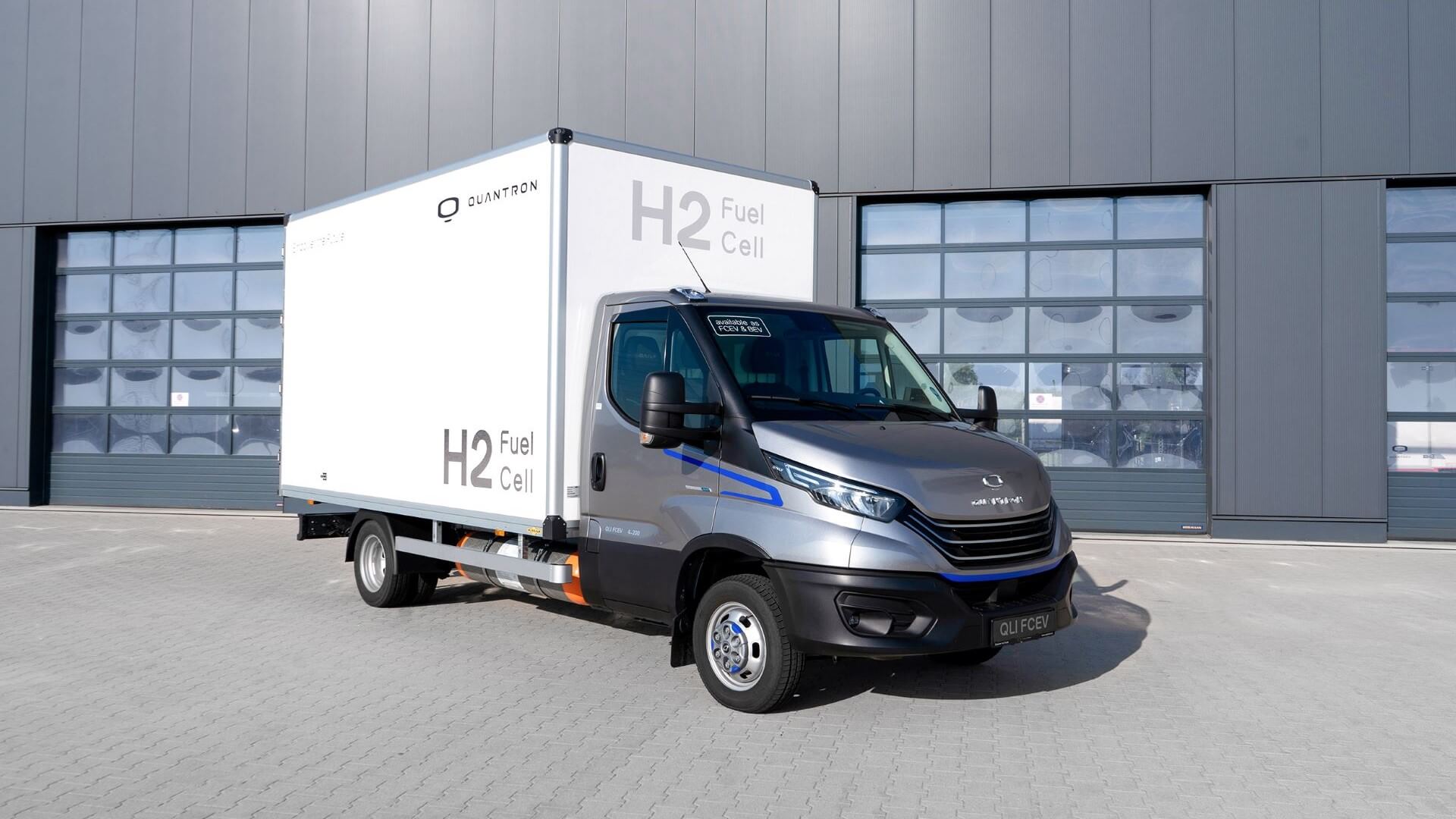 small hydgrogen powered truck parked in front of warehouse doors