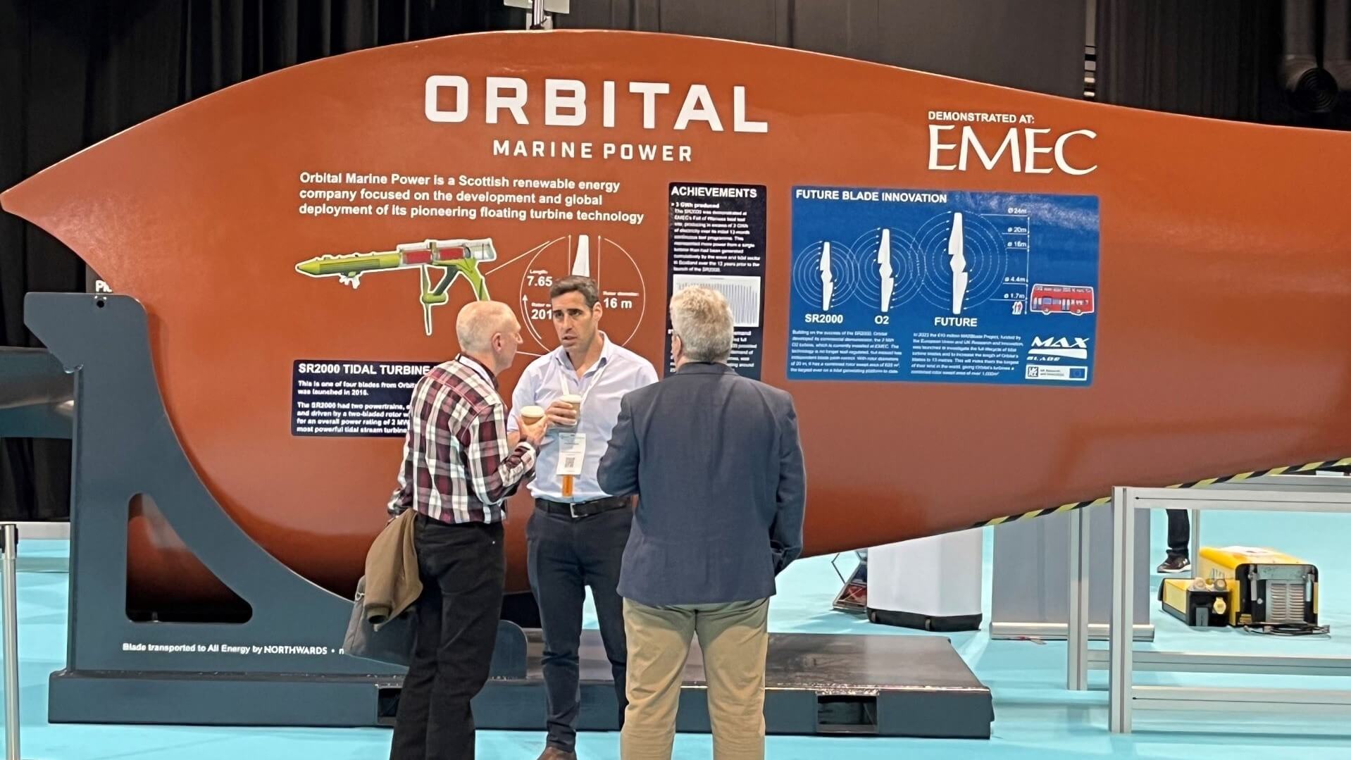 people chatting by Orbital Marine show stand