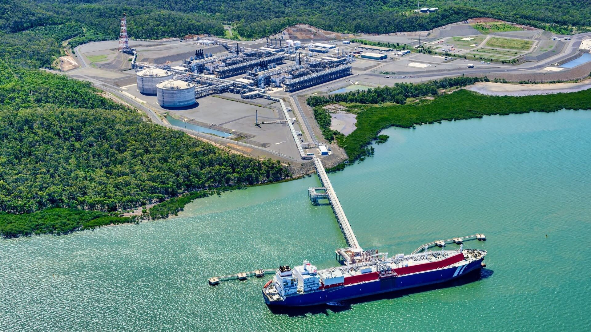 LNG tanker moored at end of jetty and loading LNG from onshore terminal