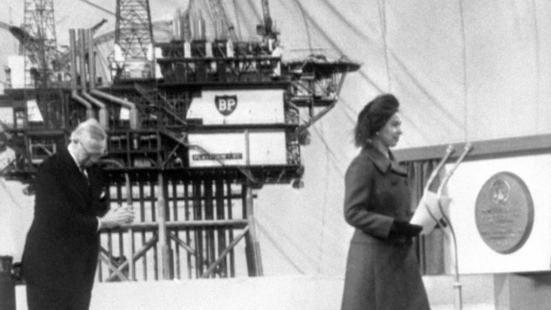 the Queen pressing button to start flow from Forties oil field with platform in background