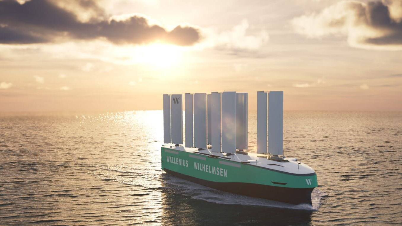 green blue tanker at sea fitted with five tall, white rectangular sectioned sails