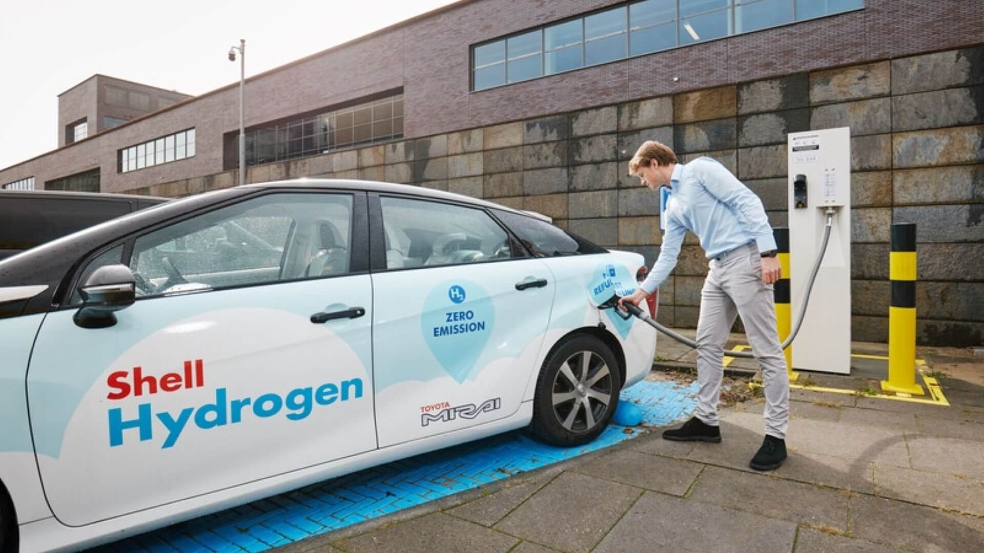 man refuelling car at hydrogen fuel pump