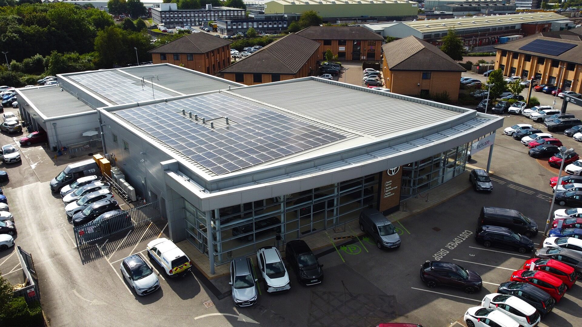 aerial view over large industrial building with roof covered in solar panels