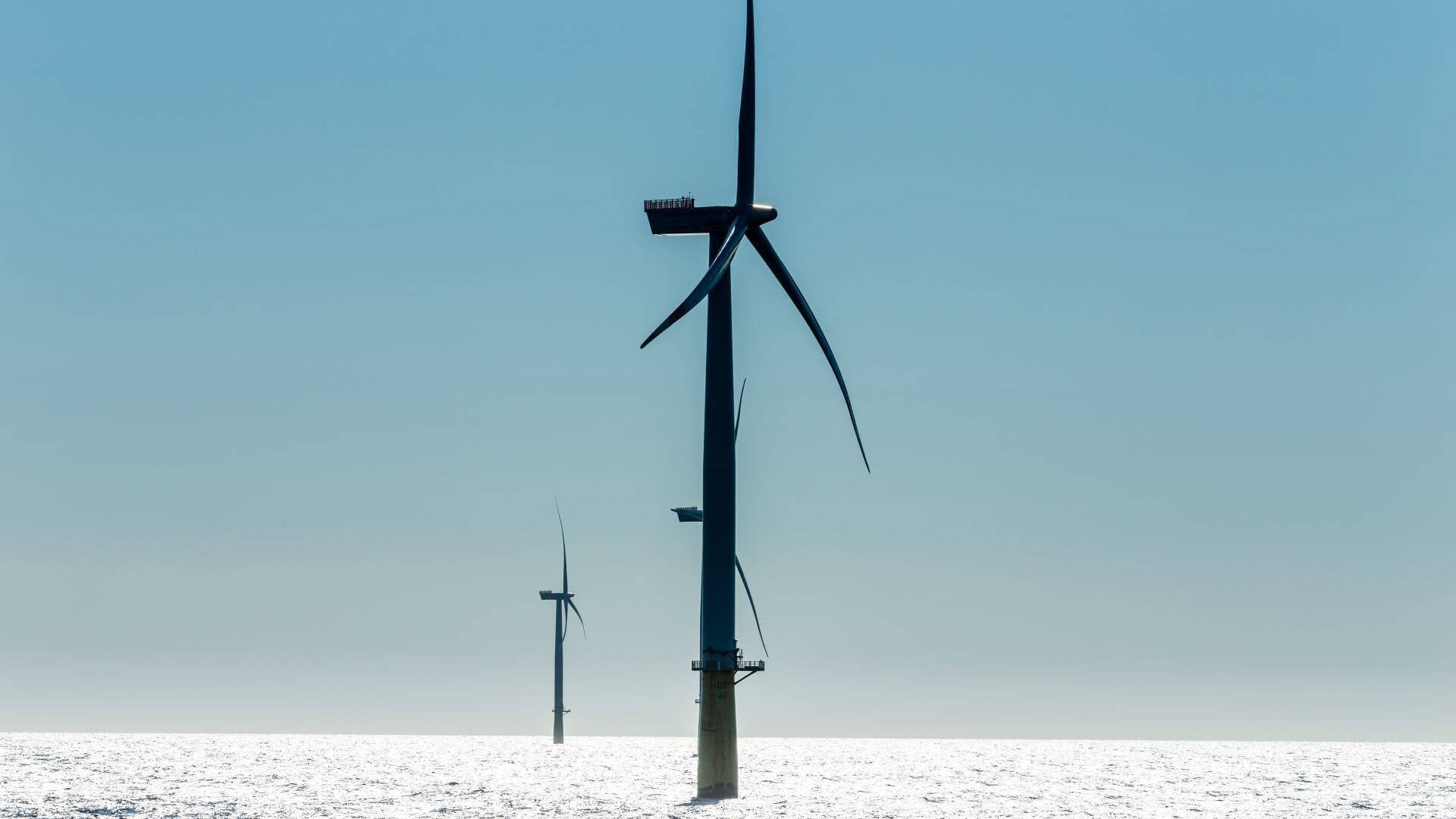 wind turbine at sea, with others in distance